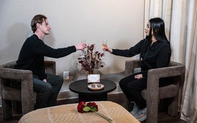 A couple toasts with champagne in a lounge area