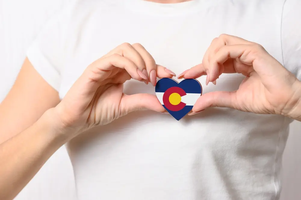 Flag of the Colorado in the shape 2063979875 Flag of the Colorado in the shape of a heart in the hands of a girl. Love Colorado.