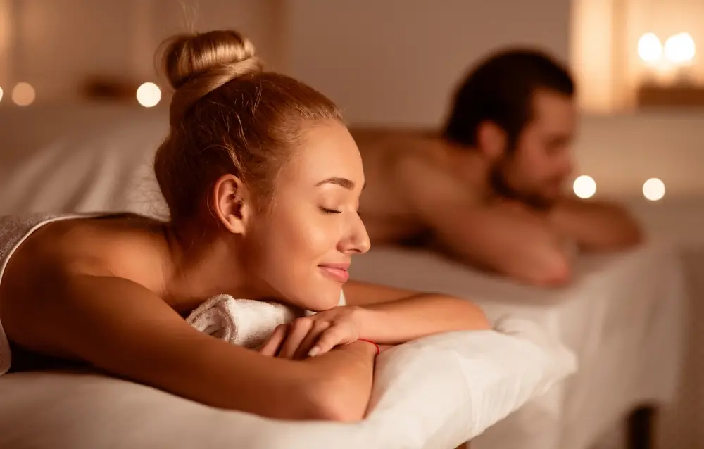Spouses Resting After Relaxing Massage Therapy Lying With Eyes Closed In Luxury Spa