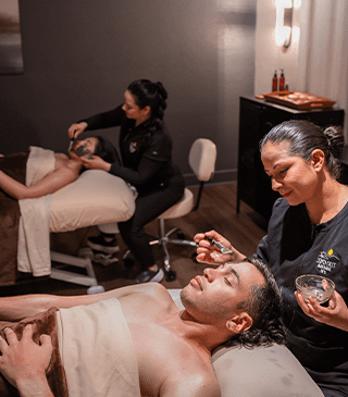 Two people getting a couples massage side-by-side.